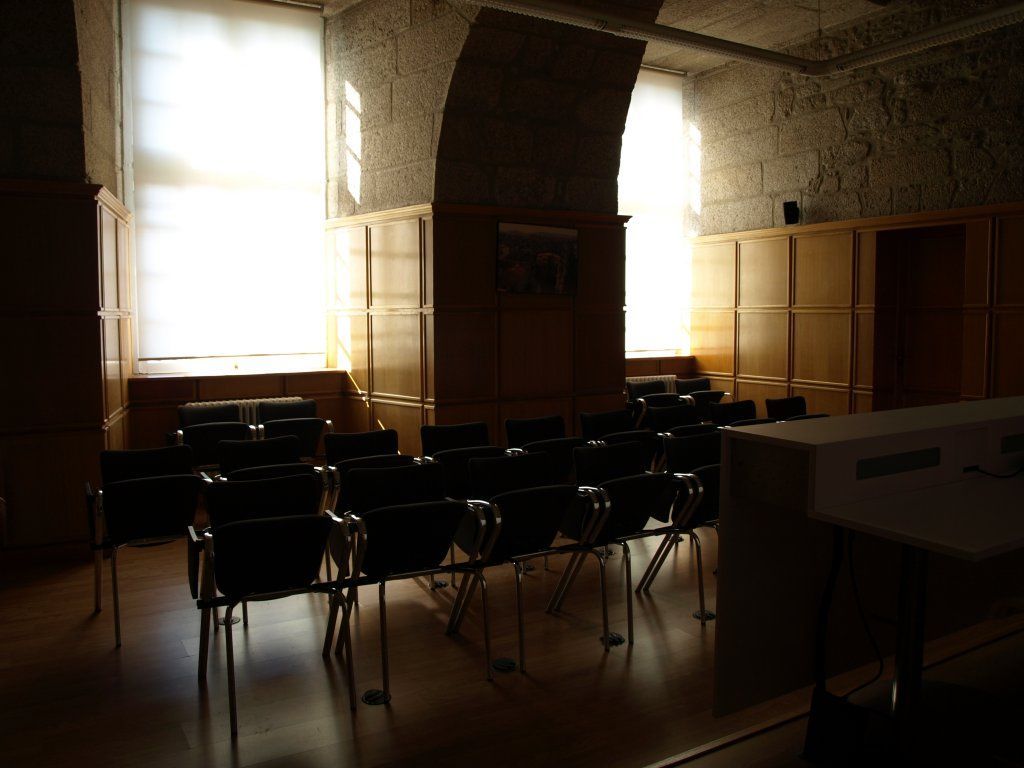 Una habitación oscura con filas de sillas en ella.