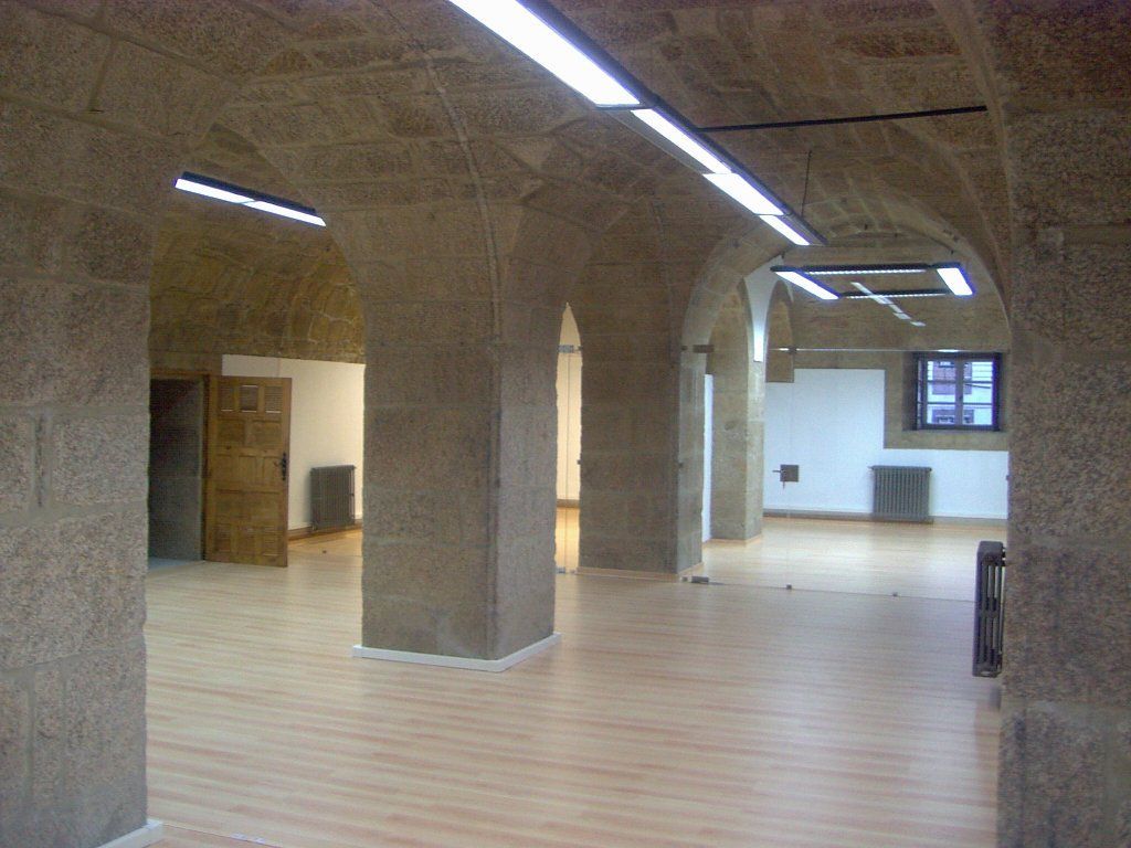 Una habitación vacía con techos abovedados y suelos de madera.