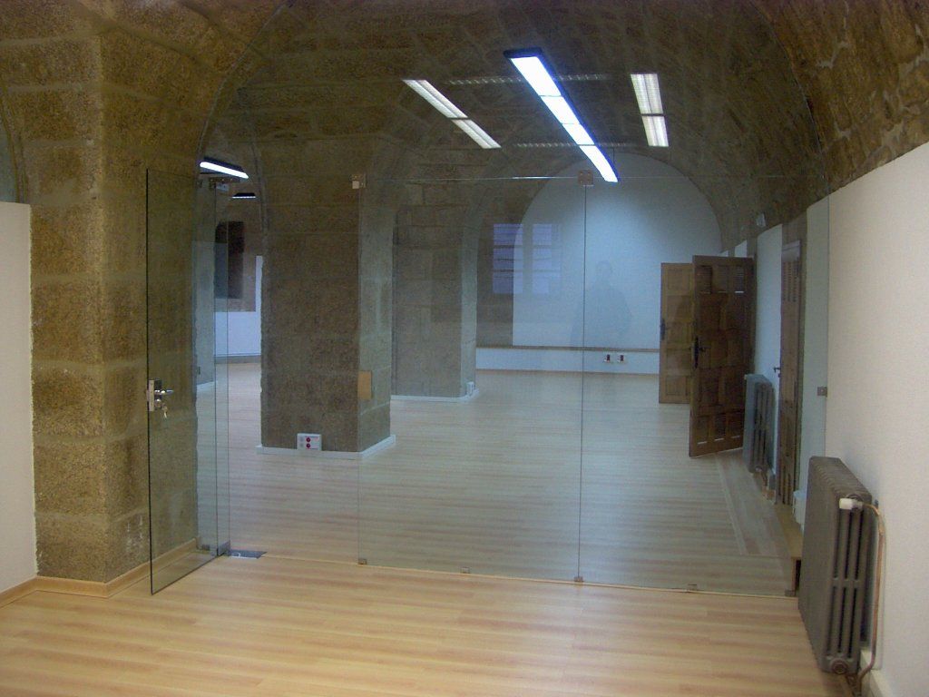 Una habitación vacía con una puerta de cristal y un radiador.