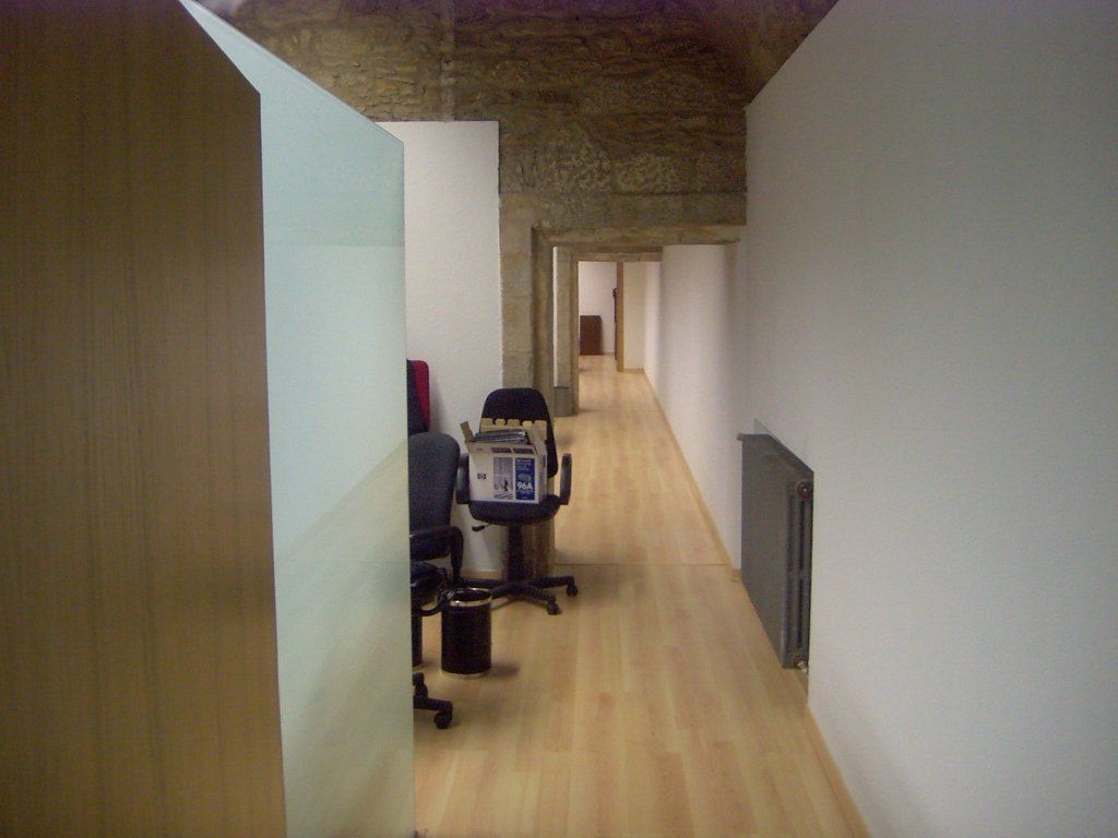 Un largo pasillo con un escritorio y una silla en el medio.