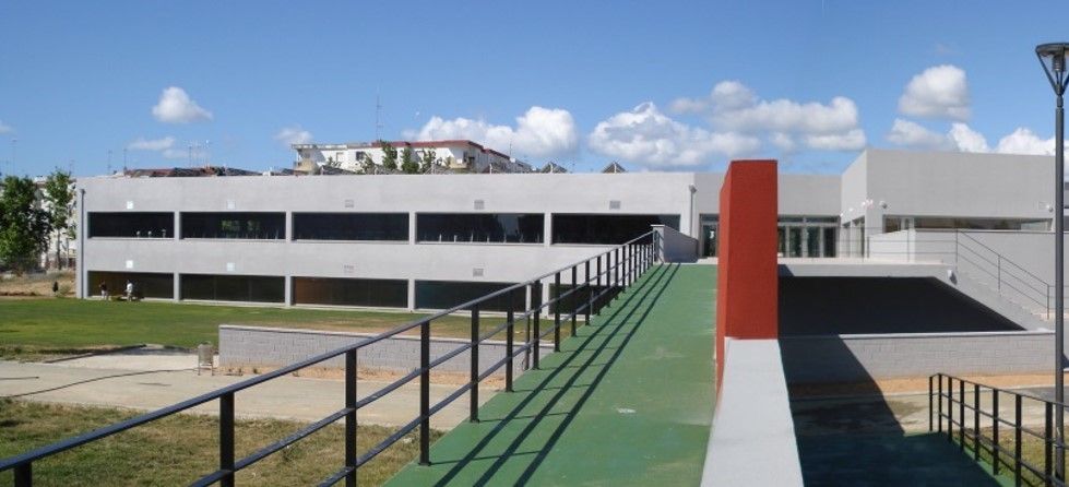 Un edificio con una pasarela verde que conduce a él.