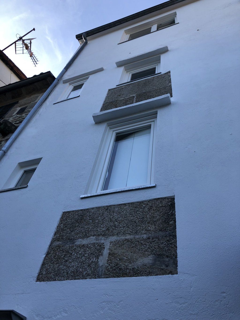 Un edificio blanco con un balcón en la parte superior.