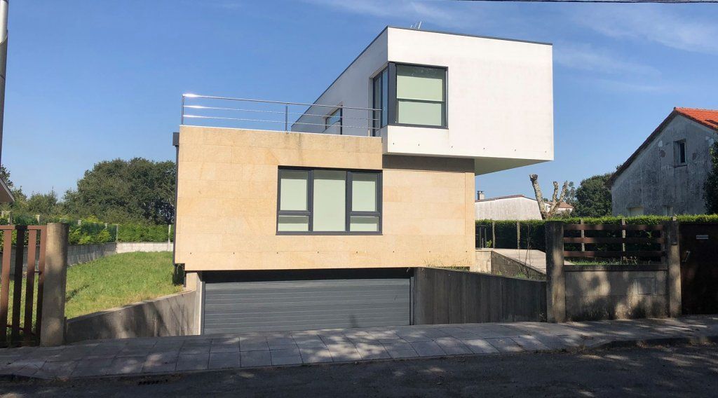 Una casa moderna con garaje y muchas ventanas.