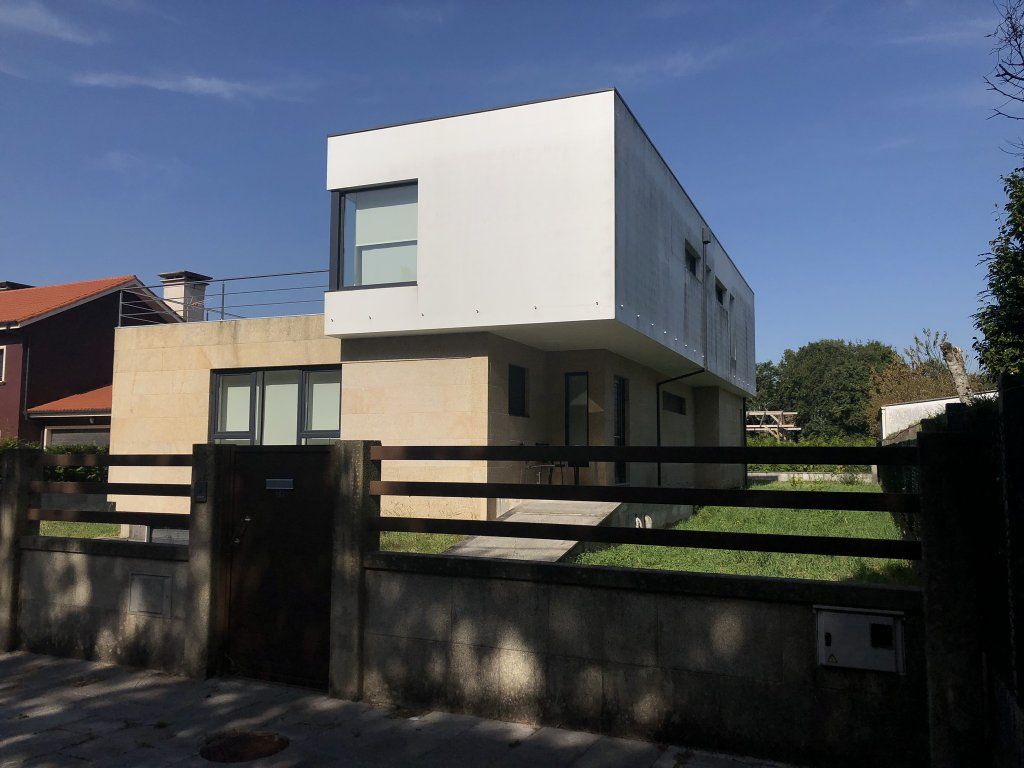 Una casa blanca con una valla de madera alrededor