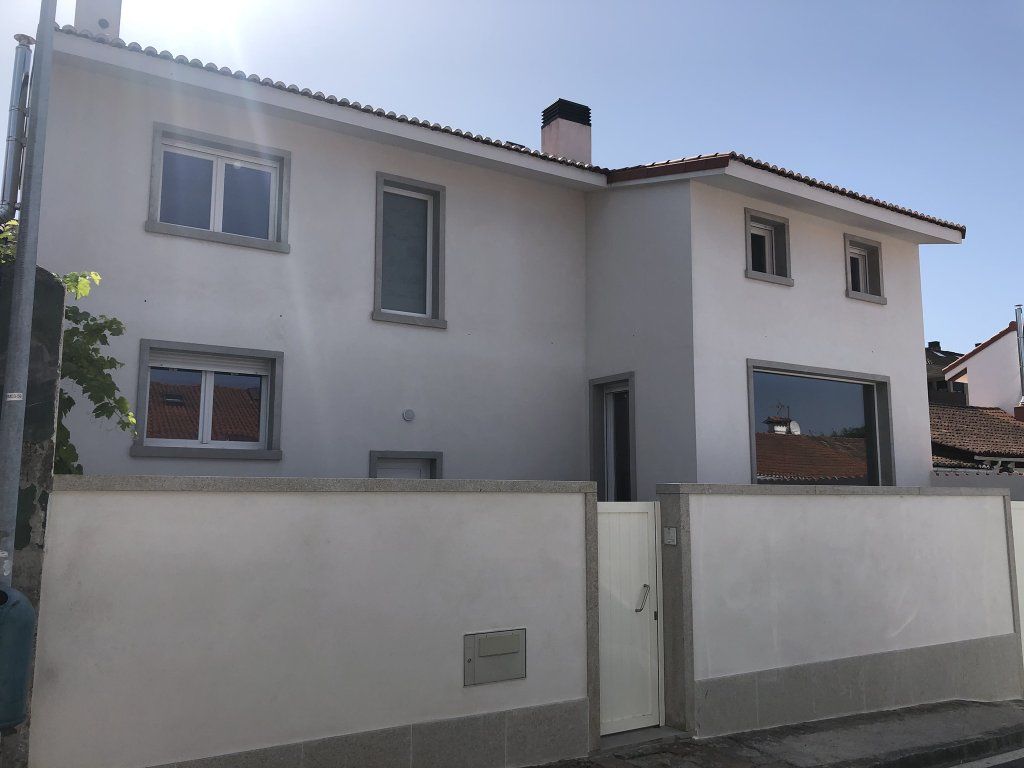 Una casa blanca con una valla delante