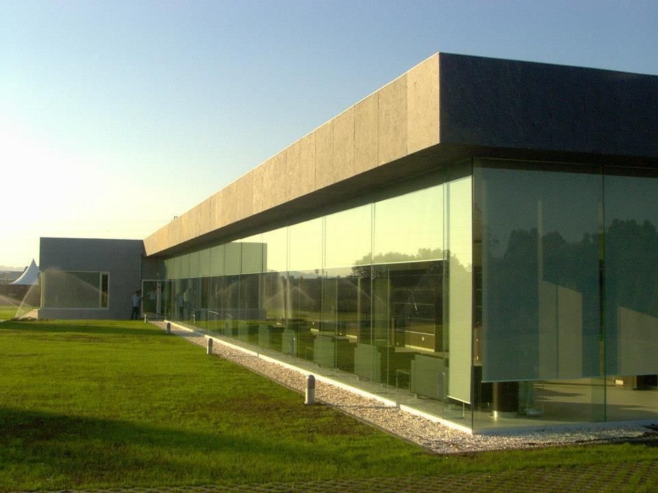 Un gran edificio con muchas ventanas y césped delante.