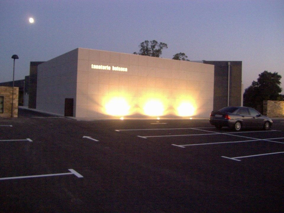Un coche está aparcado en un estacionamiento frente a un edificio que tiene la palabra instituto.