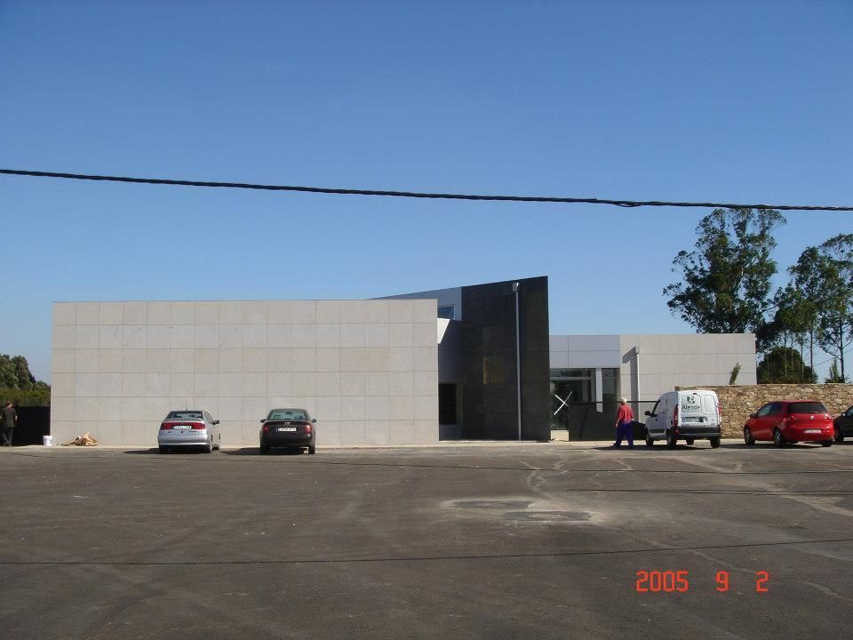 Un estacionamiento con autos estacionados frente a un edificio en 2005