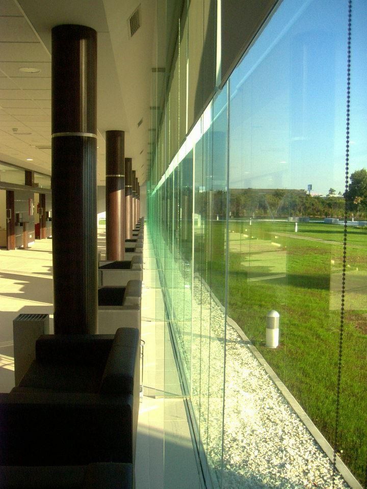 Una vista de un campo de golf a través de una pared de vidrio.