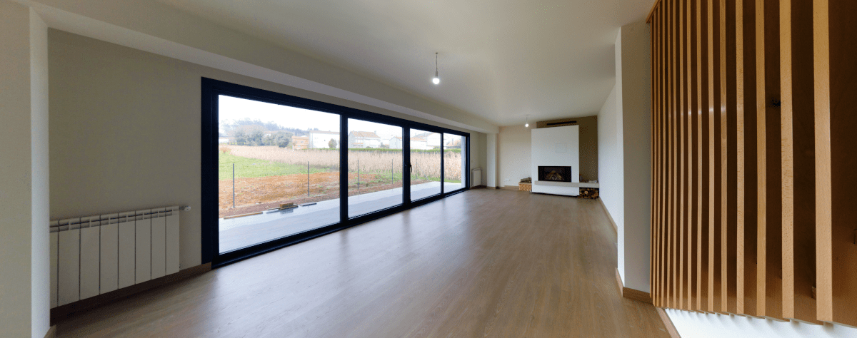 Una sala de estar vacía con puertas corredizas de vidrio y una chimenea.