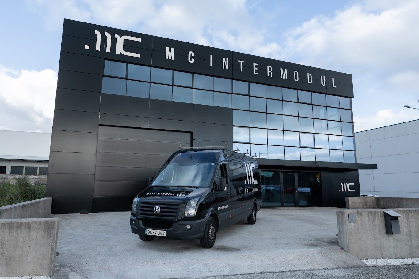 Una camioneta negra está estacionada frente a un edificio que dice mc intermodul