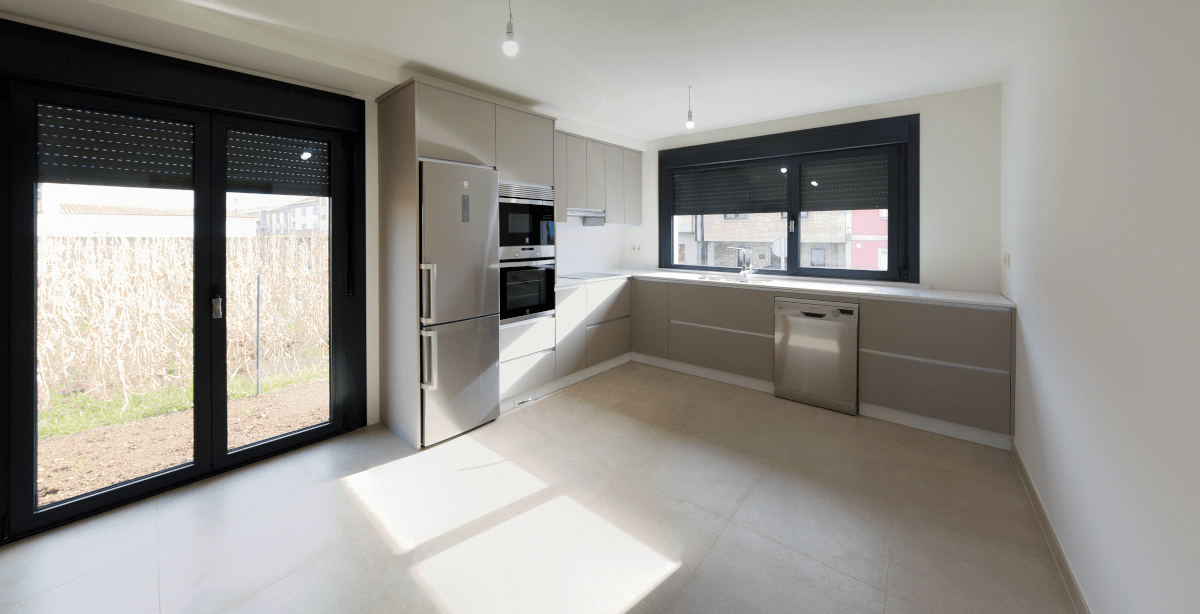 Una cocina vacía con puertas corredizas de vidrio y un refrigerador.