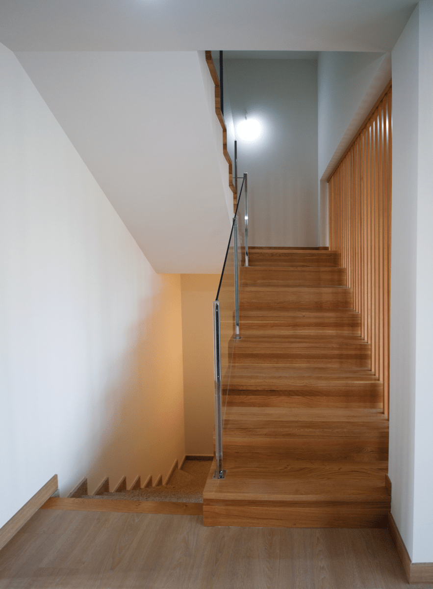 Un conjunto de escaleras de madera con barandilla de metal.