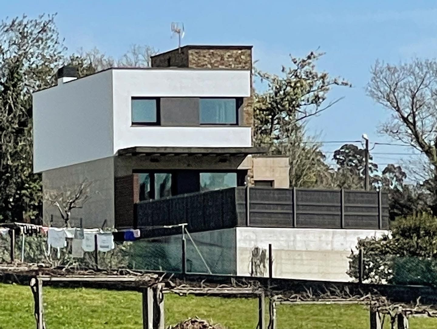 Una casa moderna con una valla delante de ella.