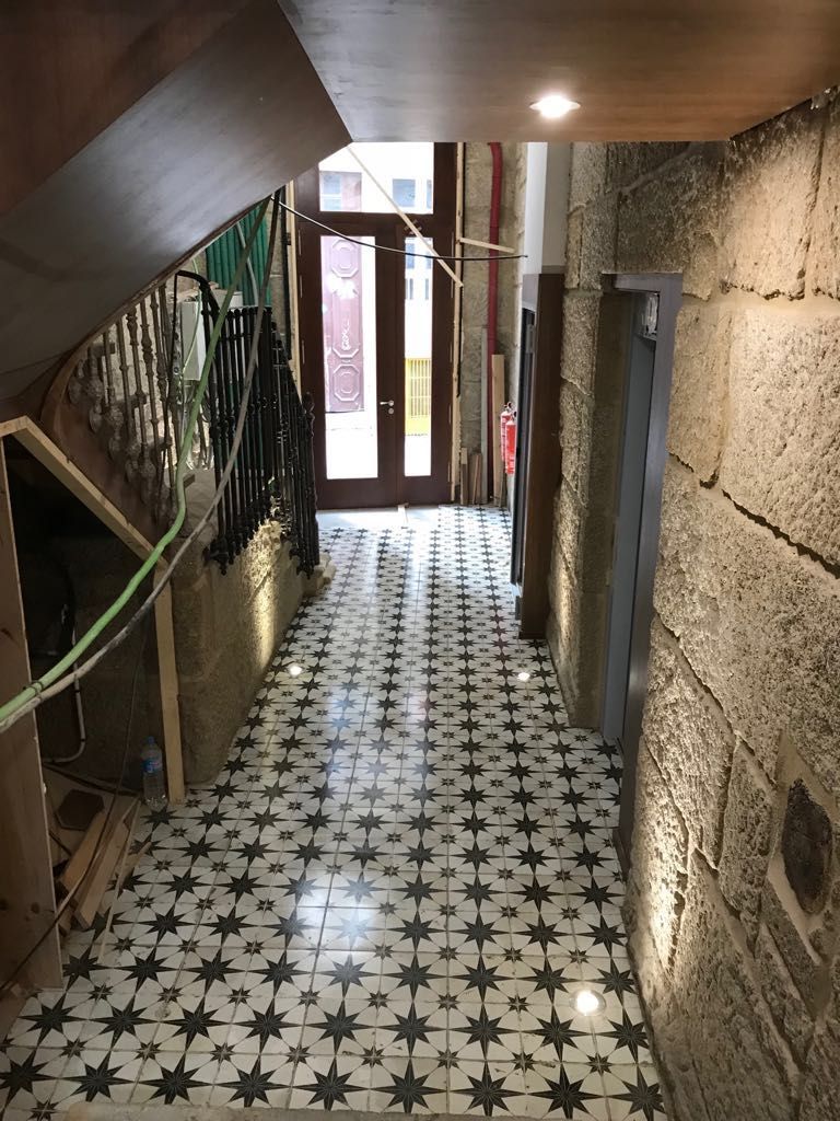 Un largo pasillo con suelo de baldosas y escaleras.