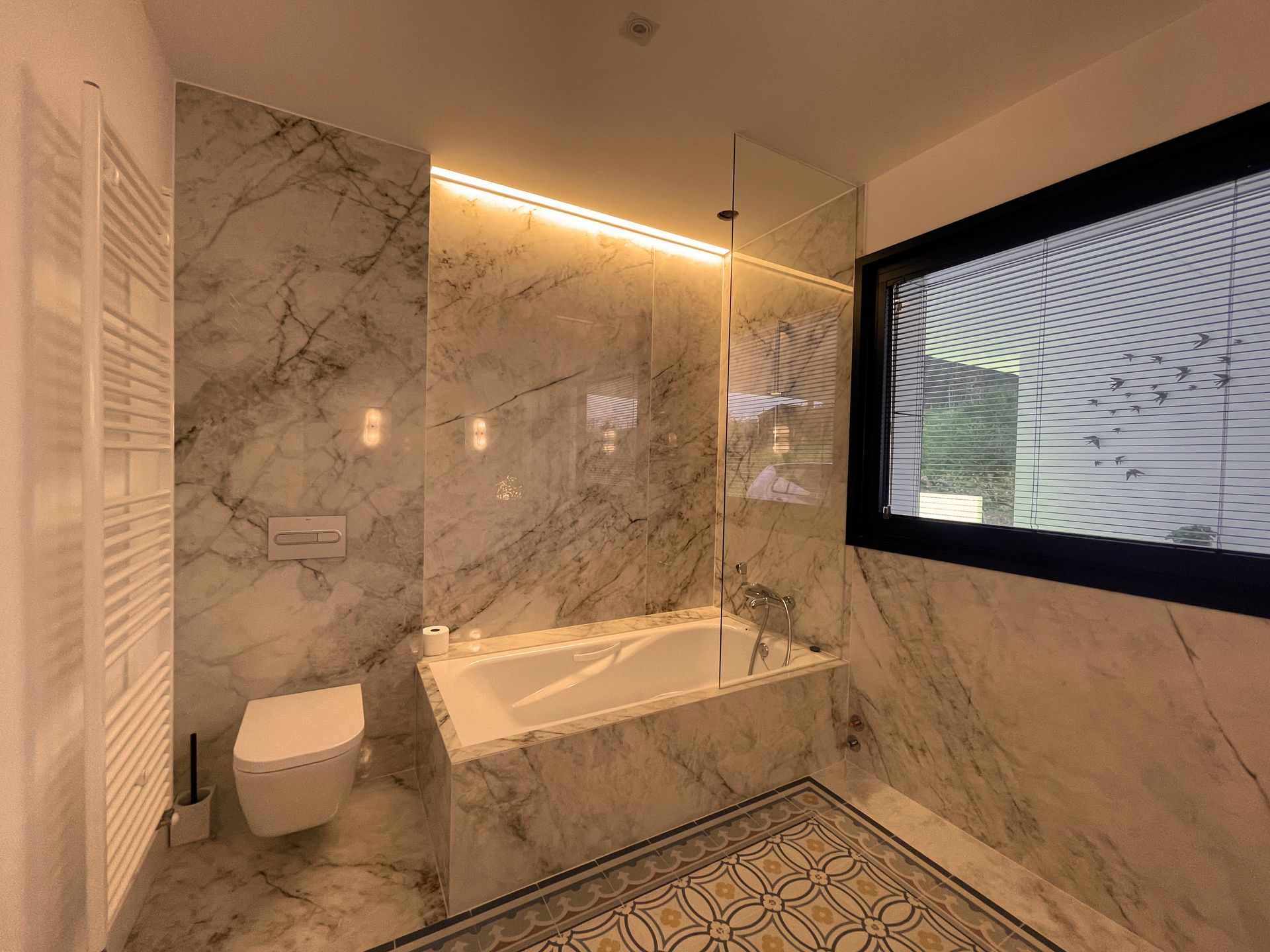 Un baño con bañera, inodoro y ventana.