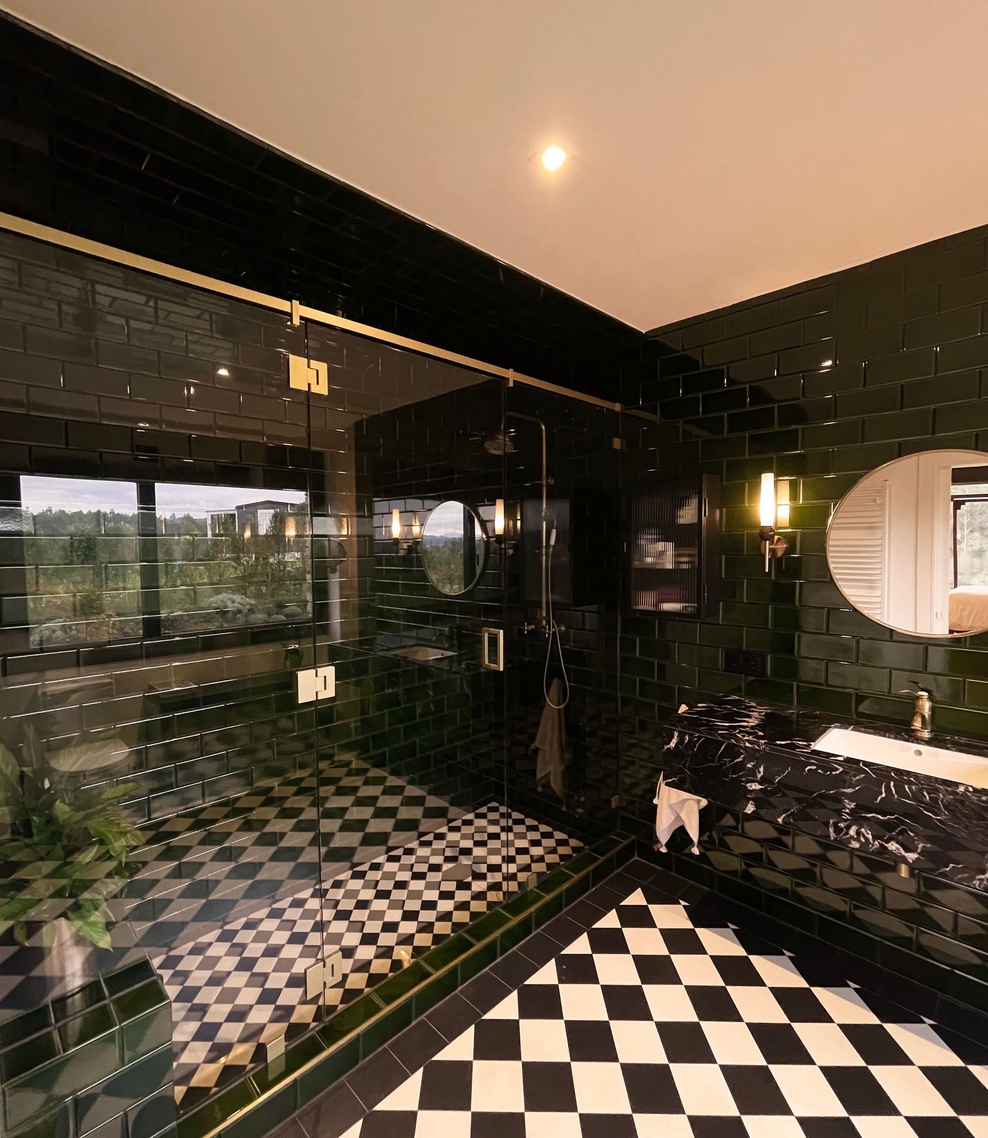 Un baño con azulejos negros y suelo de cuadros.