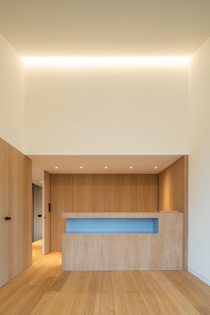 Una habitación con suelo de madera y un mostrador azul.