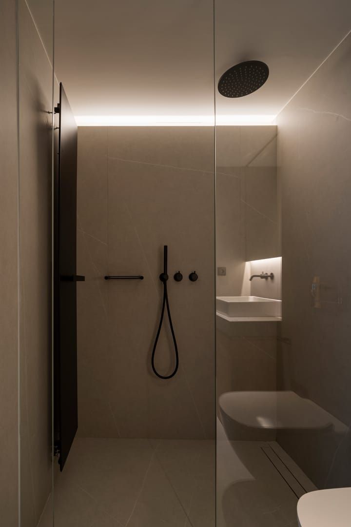 Un baño con ducha, inodoro, lavabo y cabezal de ducha.