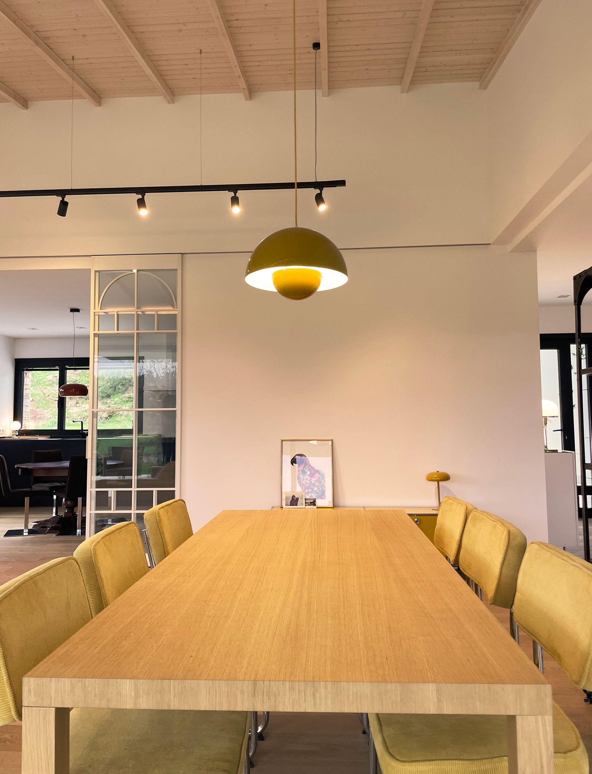 Un comedor con una larga mesa de madera y sillas amarillas.