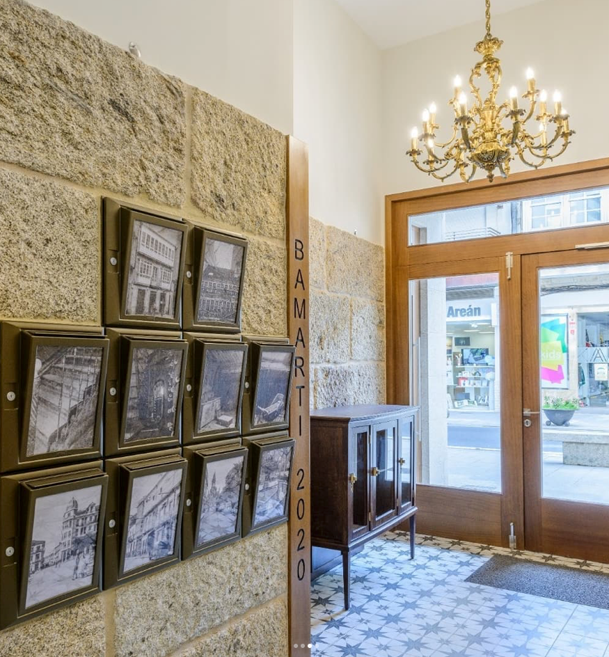 Un pasillo con una lámpara de araña colgando del techo y una pared de ladrillos.