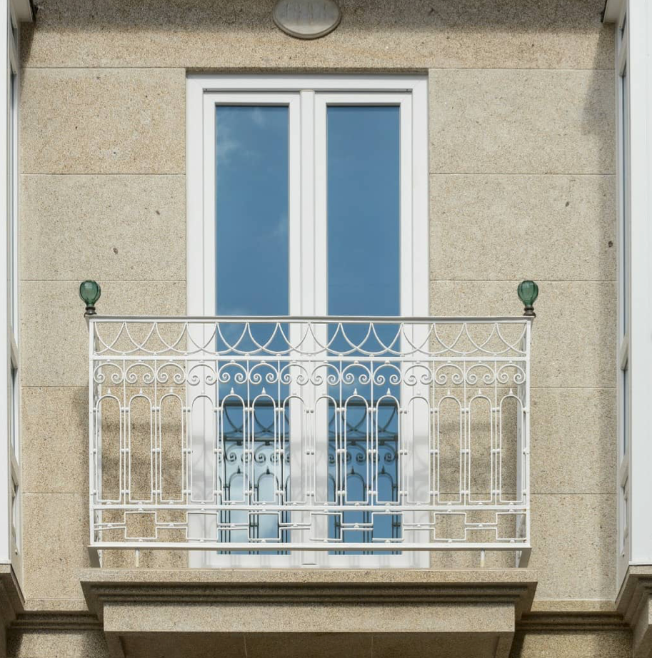 Un balcón en el costado de un edificio con una ventana.