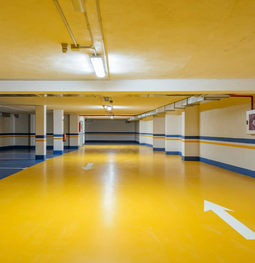 Un estacionamiento con pisos amarillos y una flecha que apunta hacia la derecha.