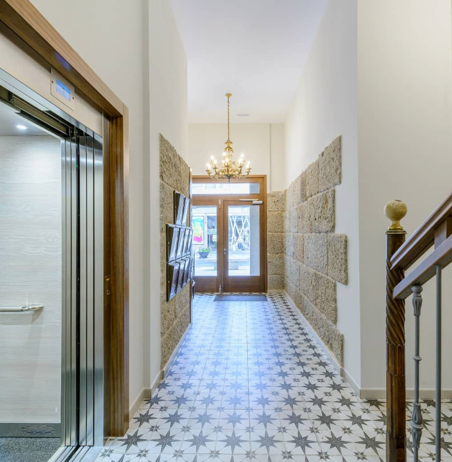 Un pasillo en un edificio con escalera y ascensor.