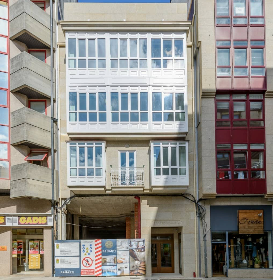 Un edificio con muchas ventanas tiene un cartel que dice no estacionar.