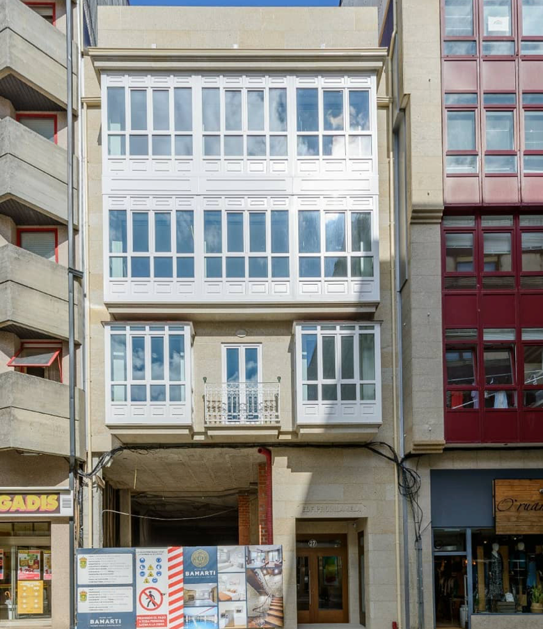 Un edificio con muchas ventanas tiene un cartel que dice no estacionar.