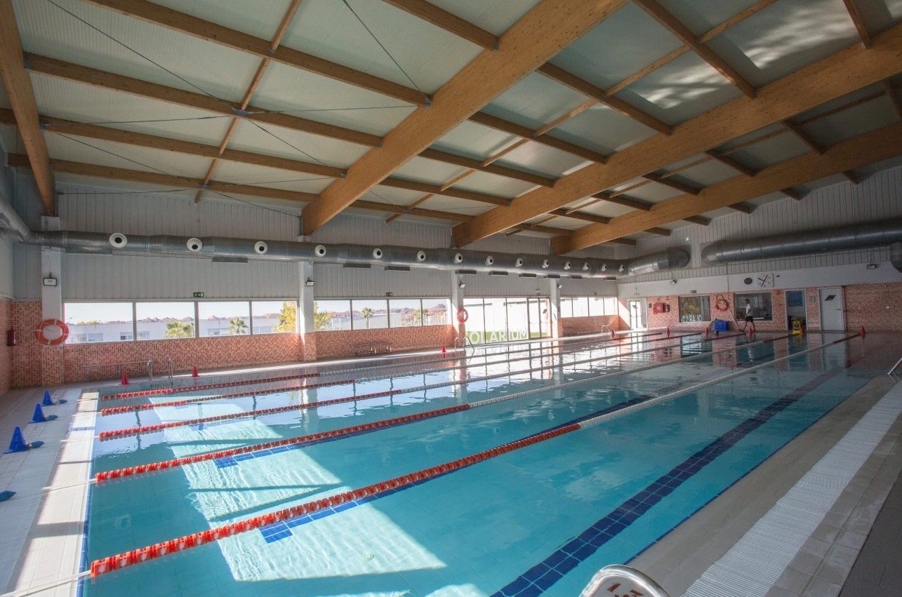 Una gran piscina cubierta con techo de madera.