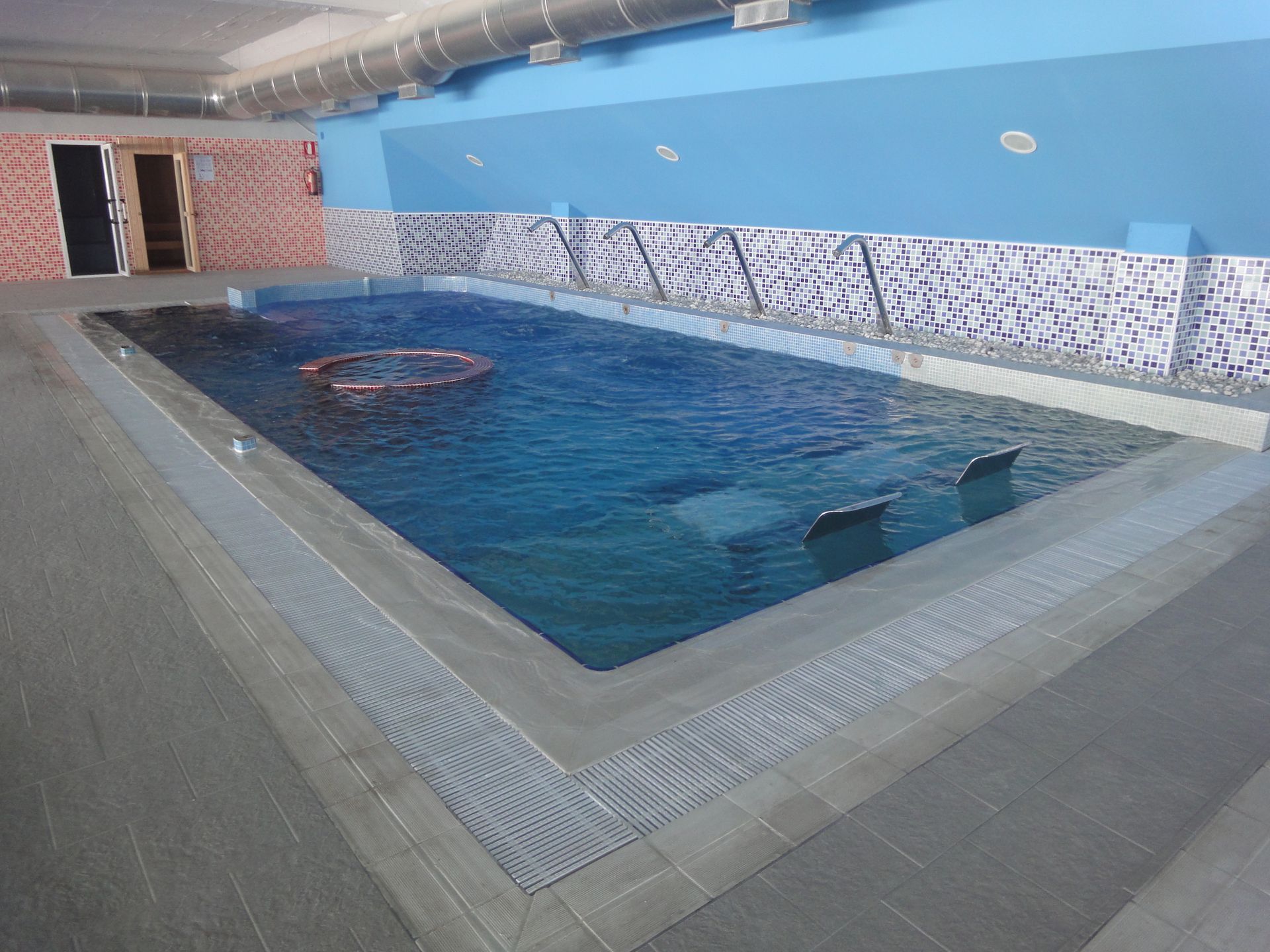 Una gran piscina cubierta con paredes azules