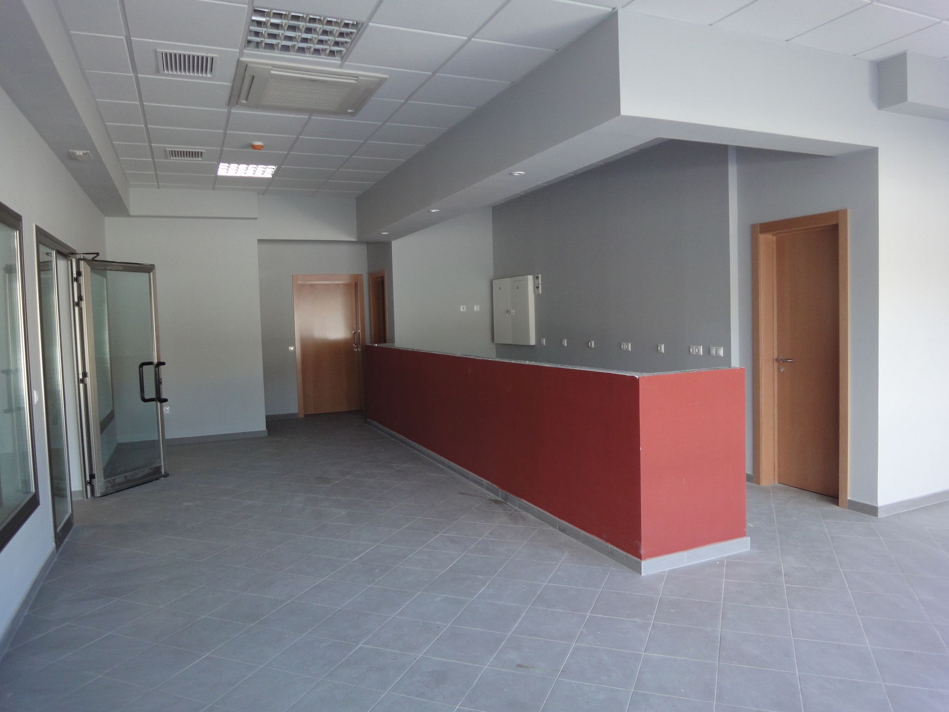 Una habitación vacía con un mostrador rojo en el medio.