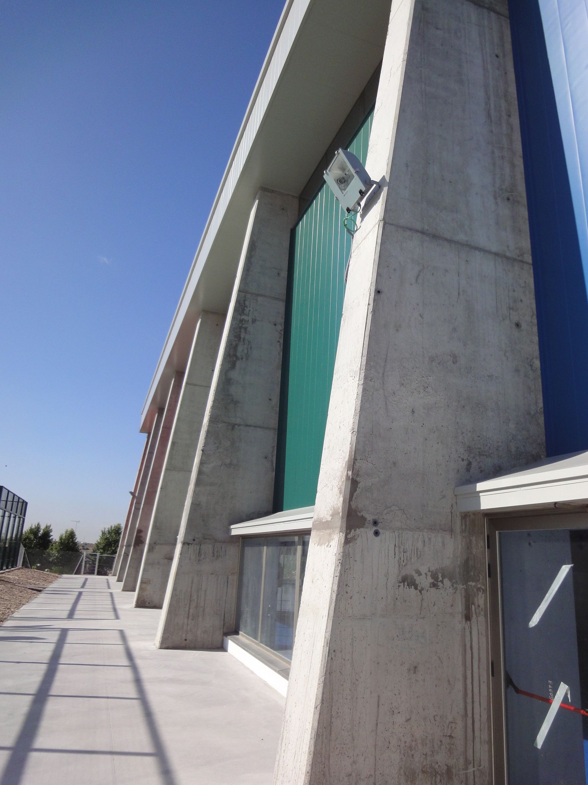 Un gran edificio de hormigón con un reloj en el lateral.
