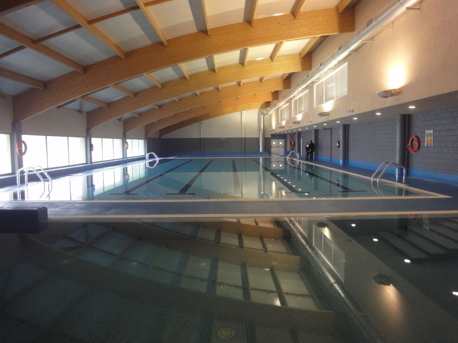 Una gran piscina cubierta con techo de madera.