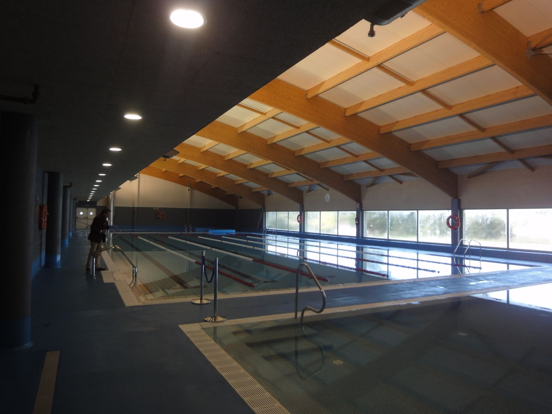 Una gran piscina cubierta con techo de madera.
