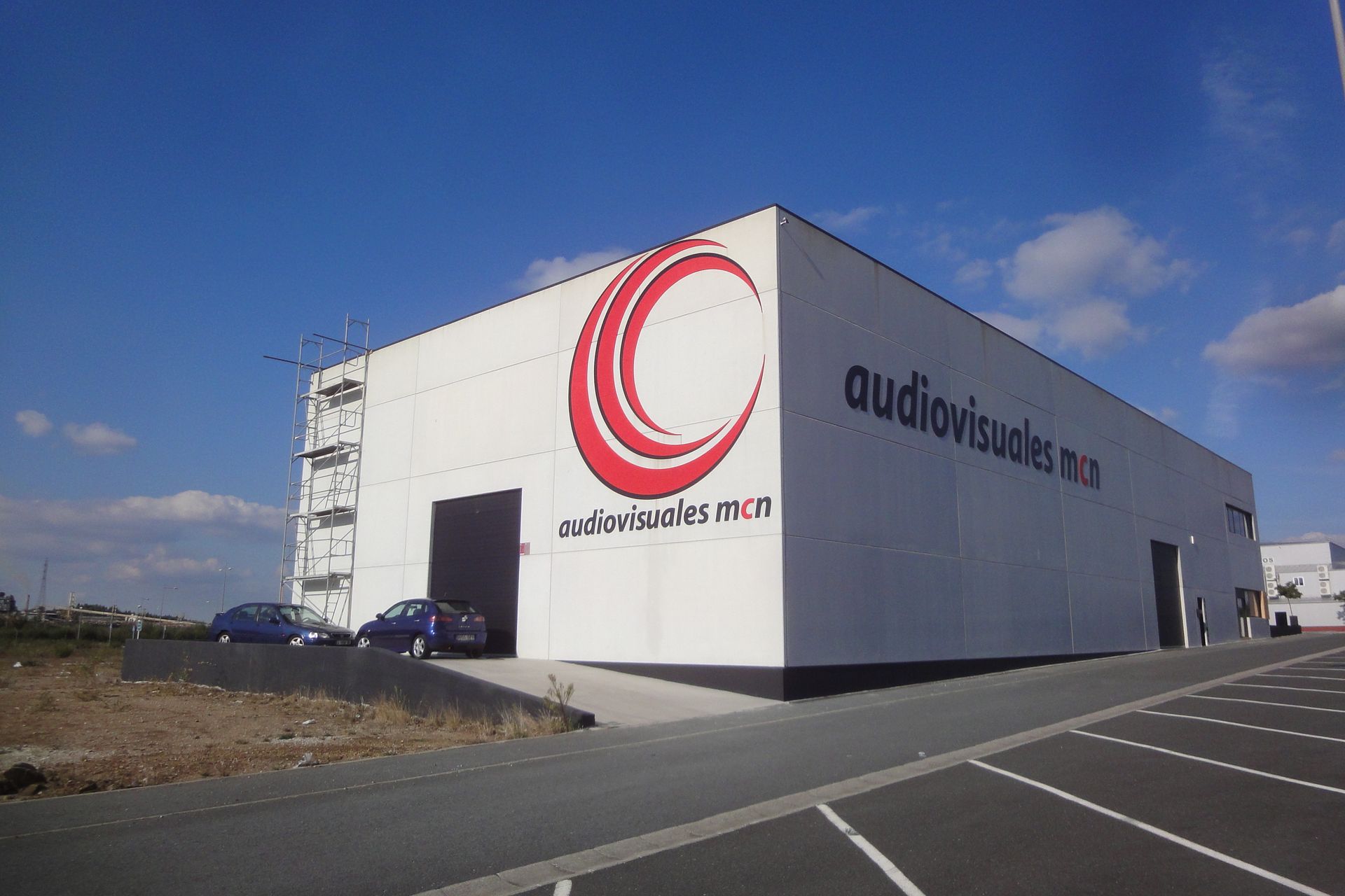 Un edificio blanco con una C roja al costado.