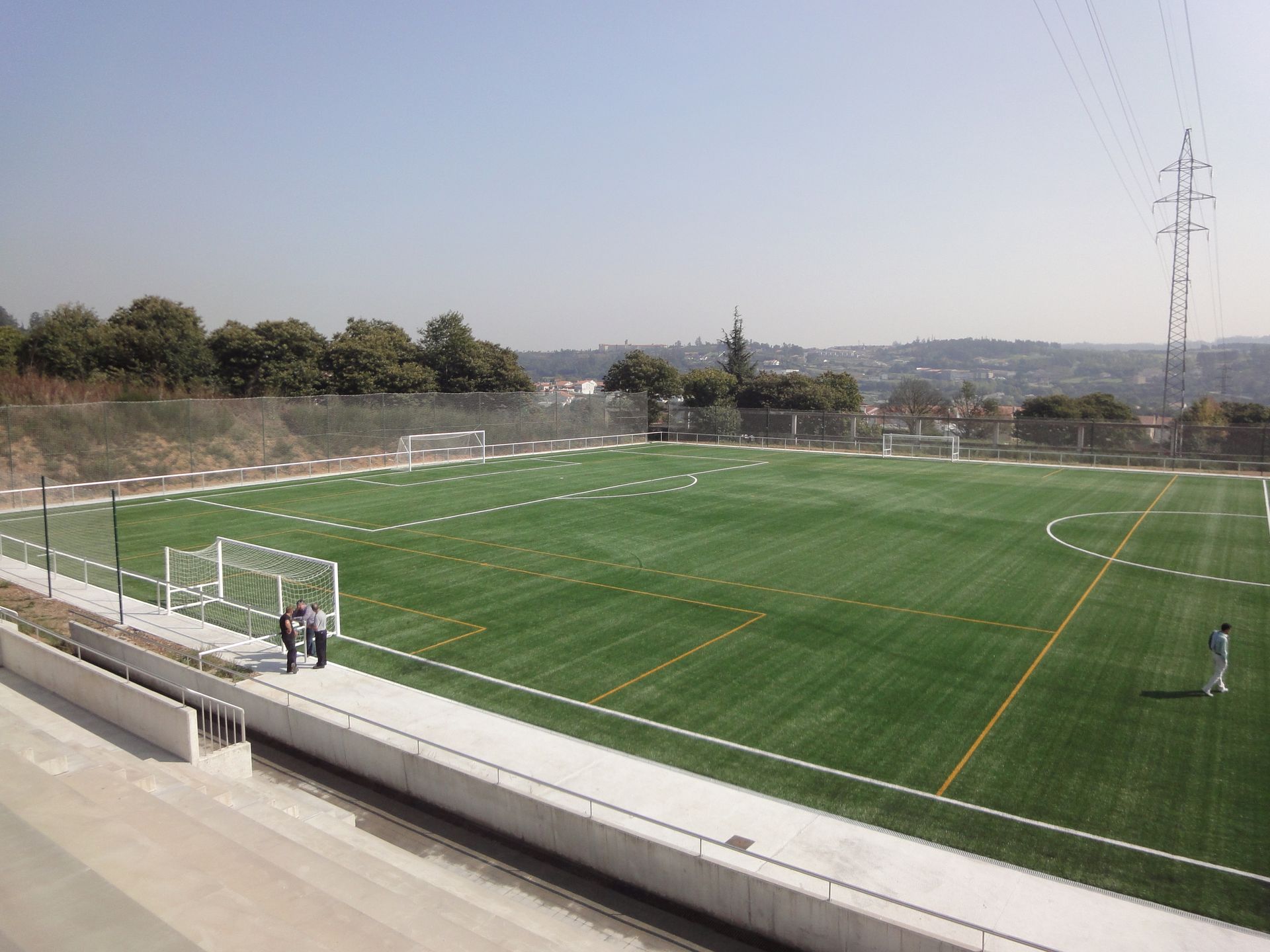 Una vista aérea de un campo de fútbol con árboles al fondo.