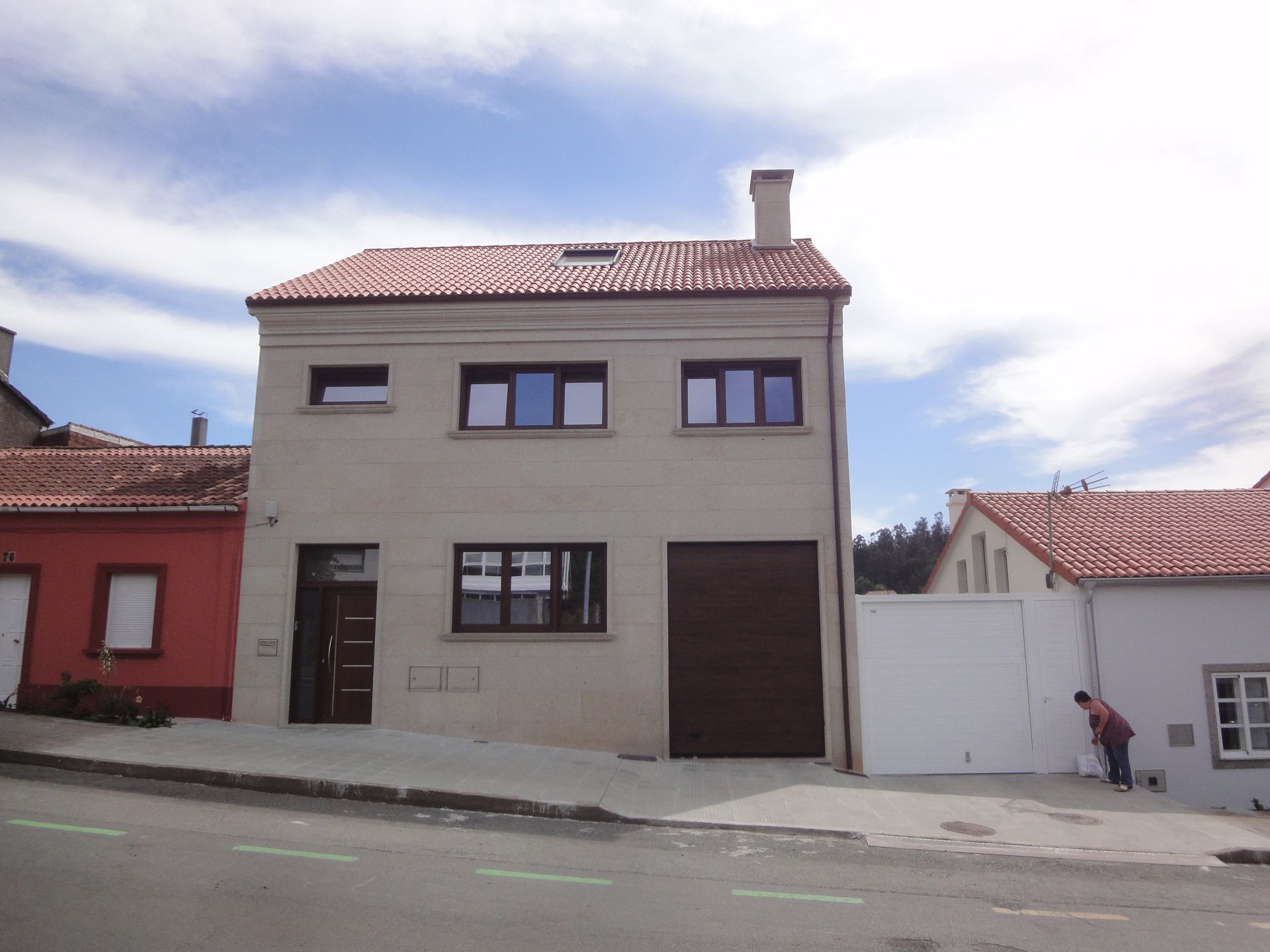 Una casa con techo rojo y garaje blanco