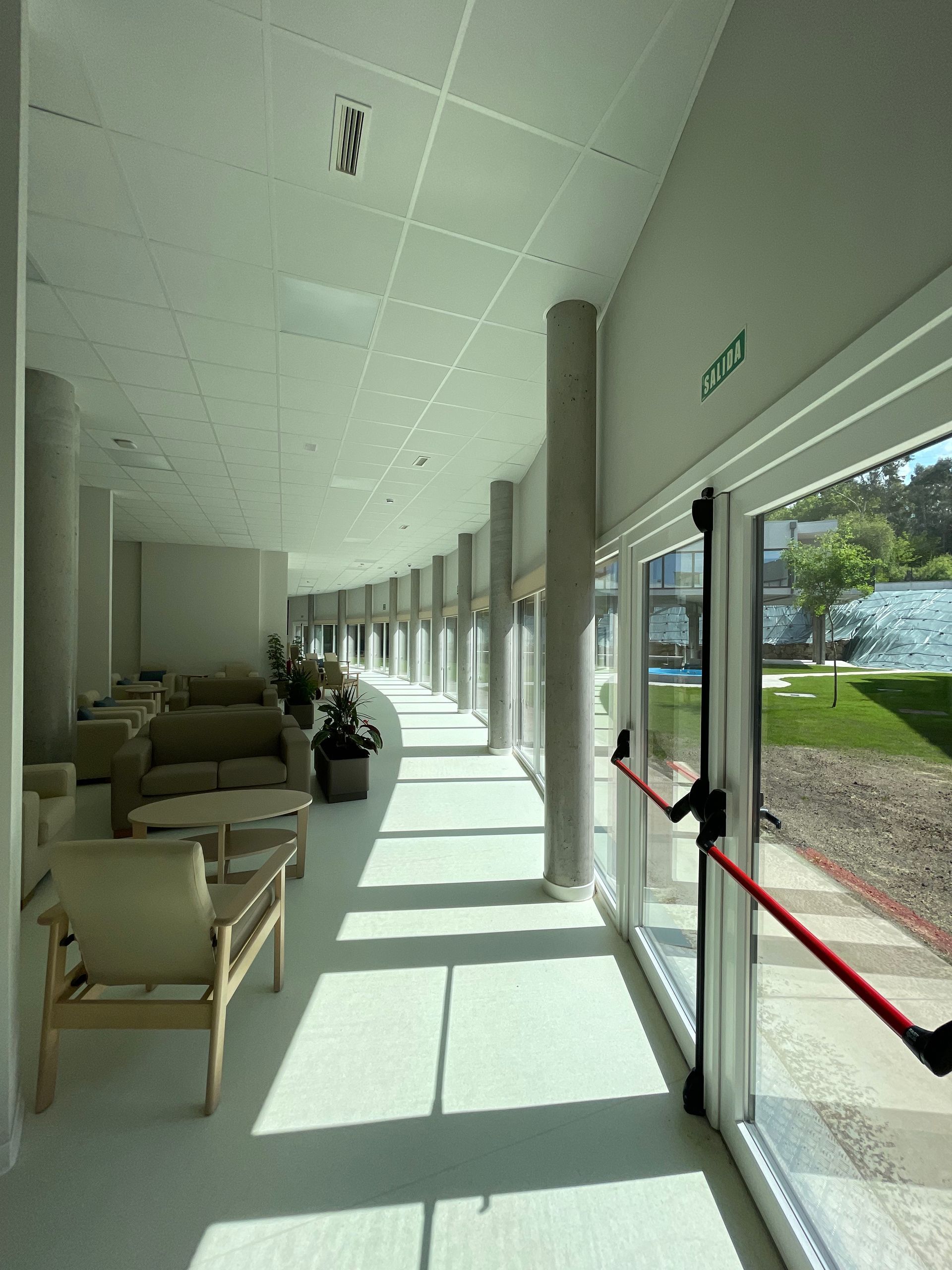 Un largo pasillo en un edificio con muchas ventanas.