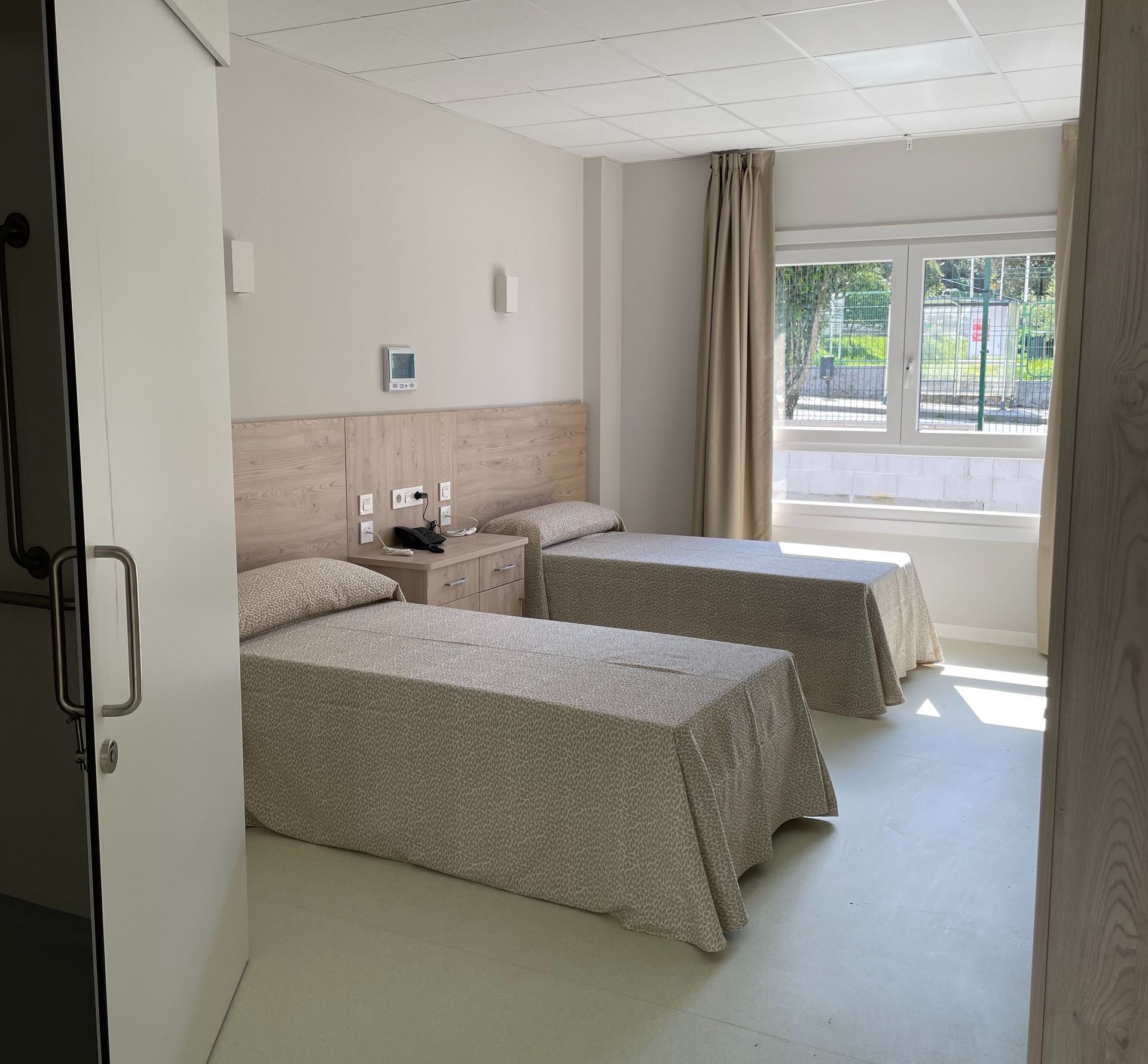 Una habitación de hotel con dos camas y una ventana.