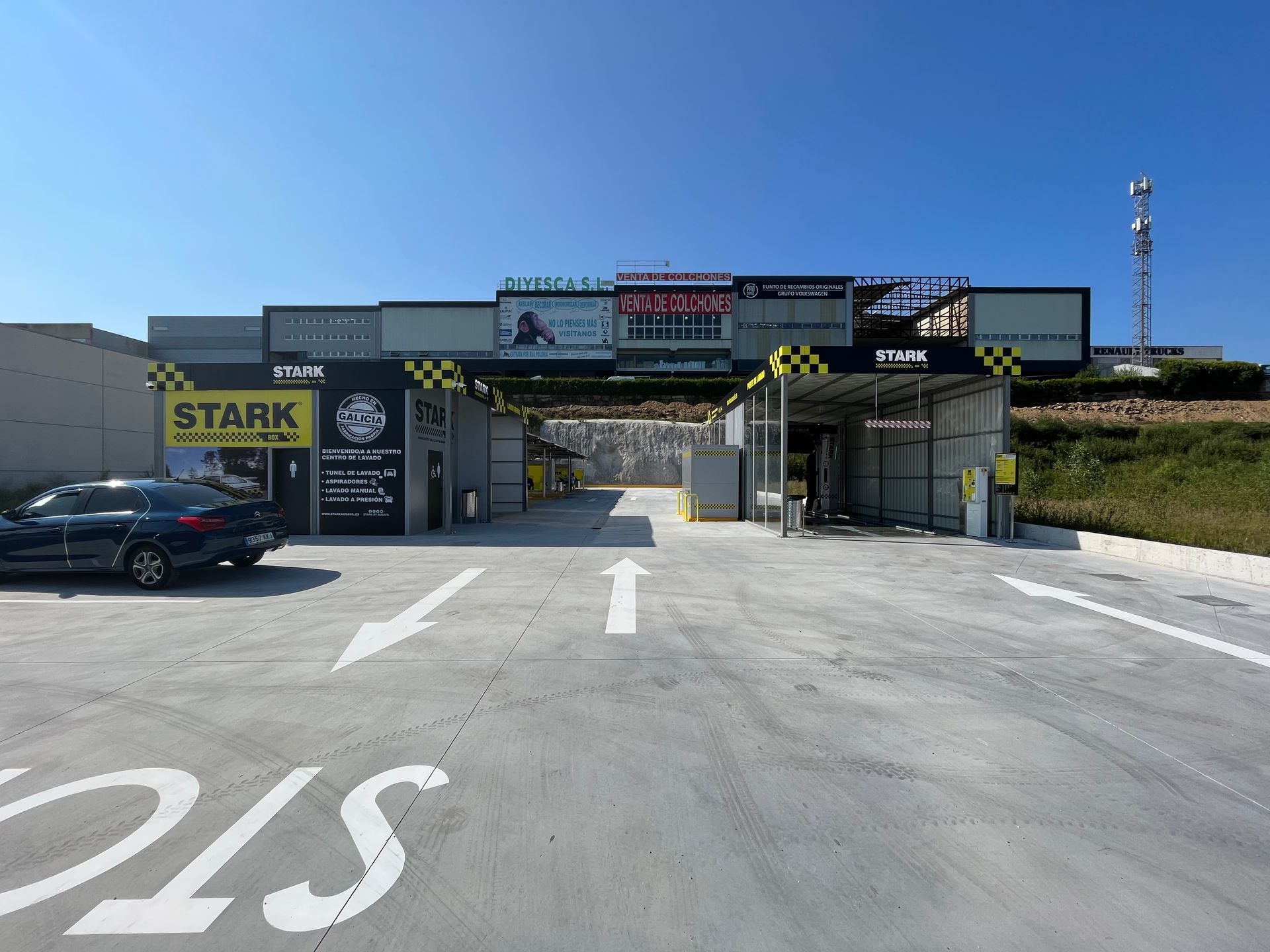 Un coche está aparcado delante de un lavadero de coches.