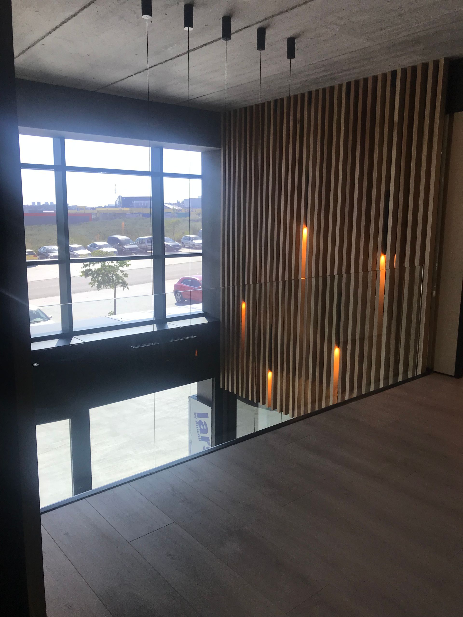 Una habitación con una gran ventana y una pared de madera.