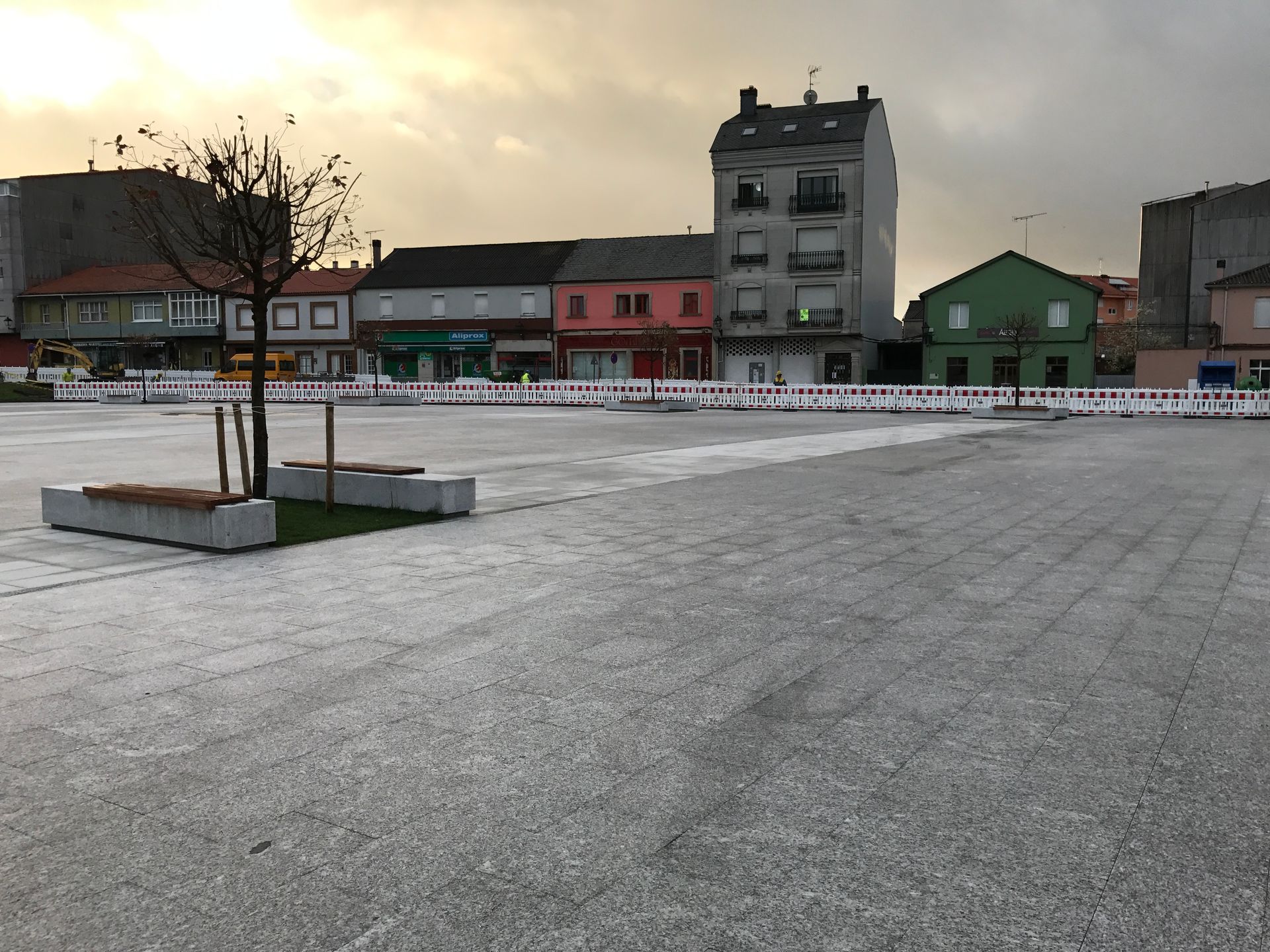Un gran estacionamiento vacío con edificios al fondo.