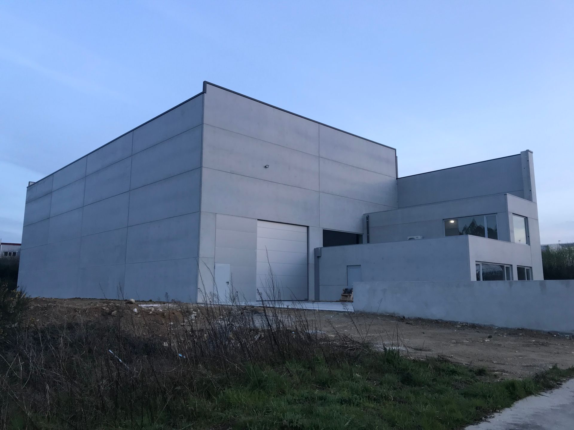 Un gran edificio blanco está situado en medio de un campo.