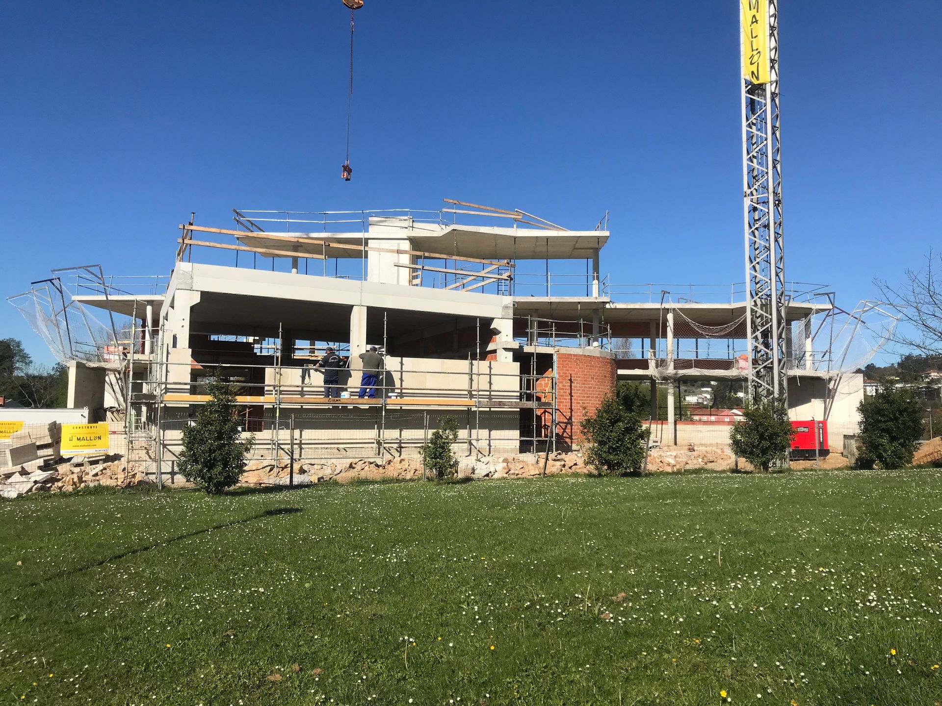 Un gran edificio en construcción con una grúa al fondo.