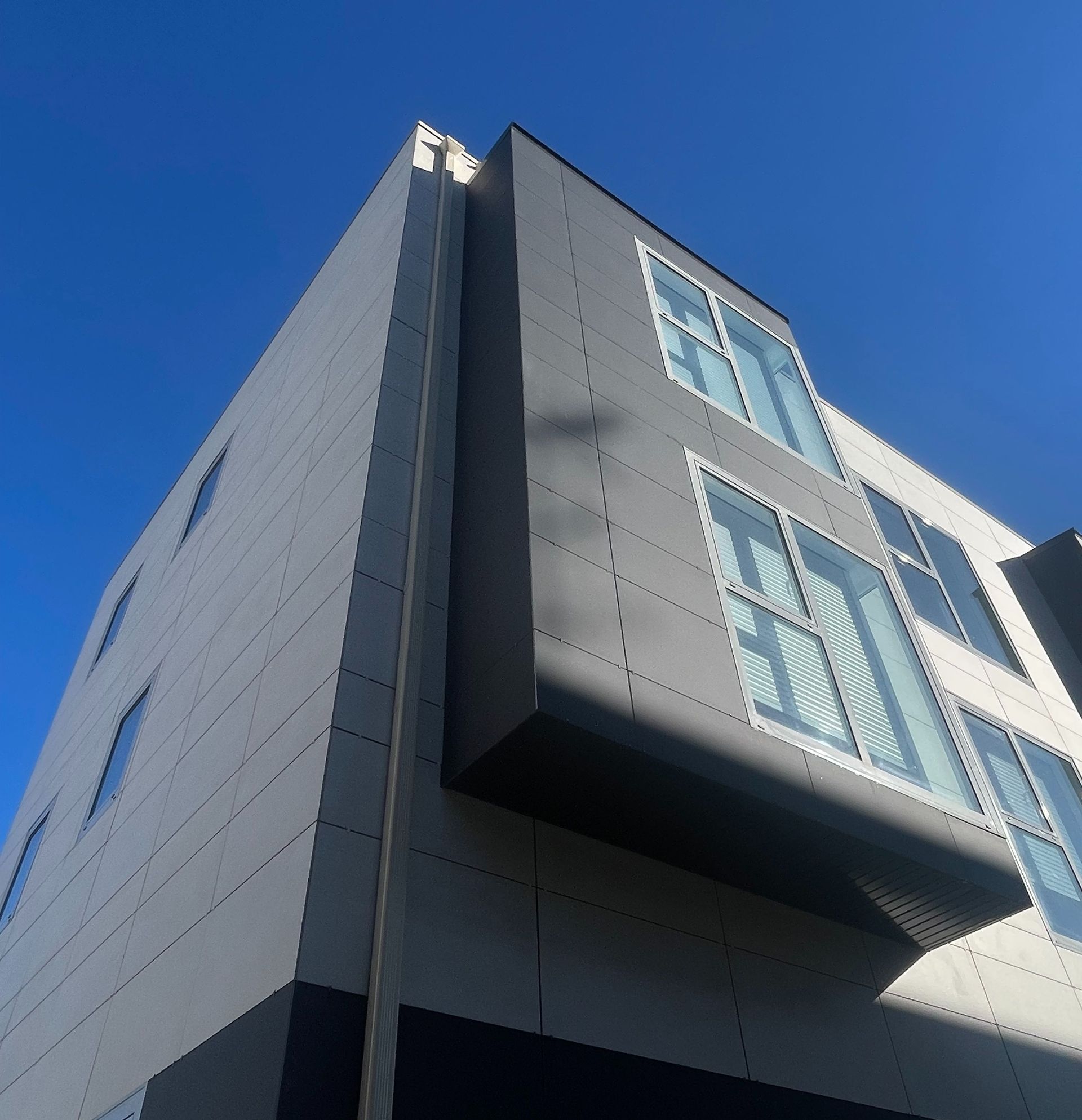 Mirando hacia arriba a un edificio con un cielo azul en el fondo