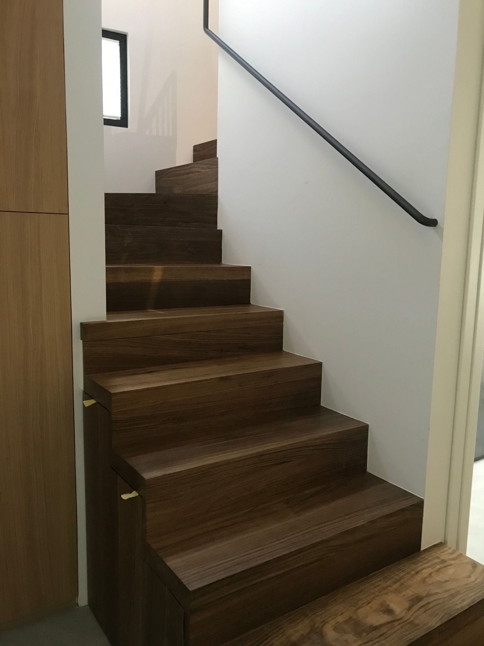Una escalera de madera con barandilla de metal en una habitación.
