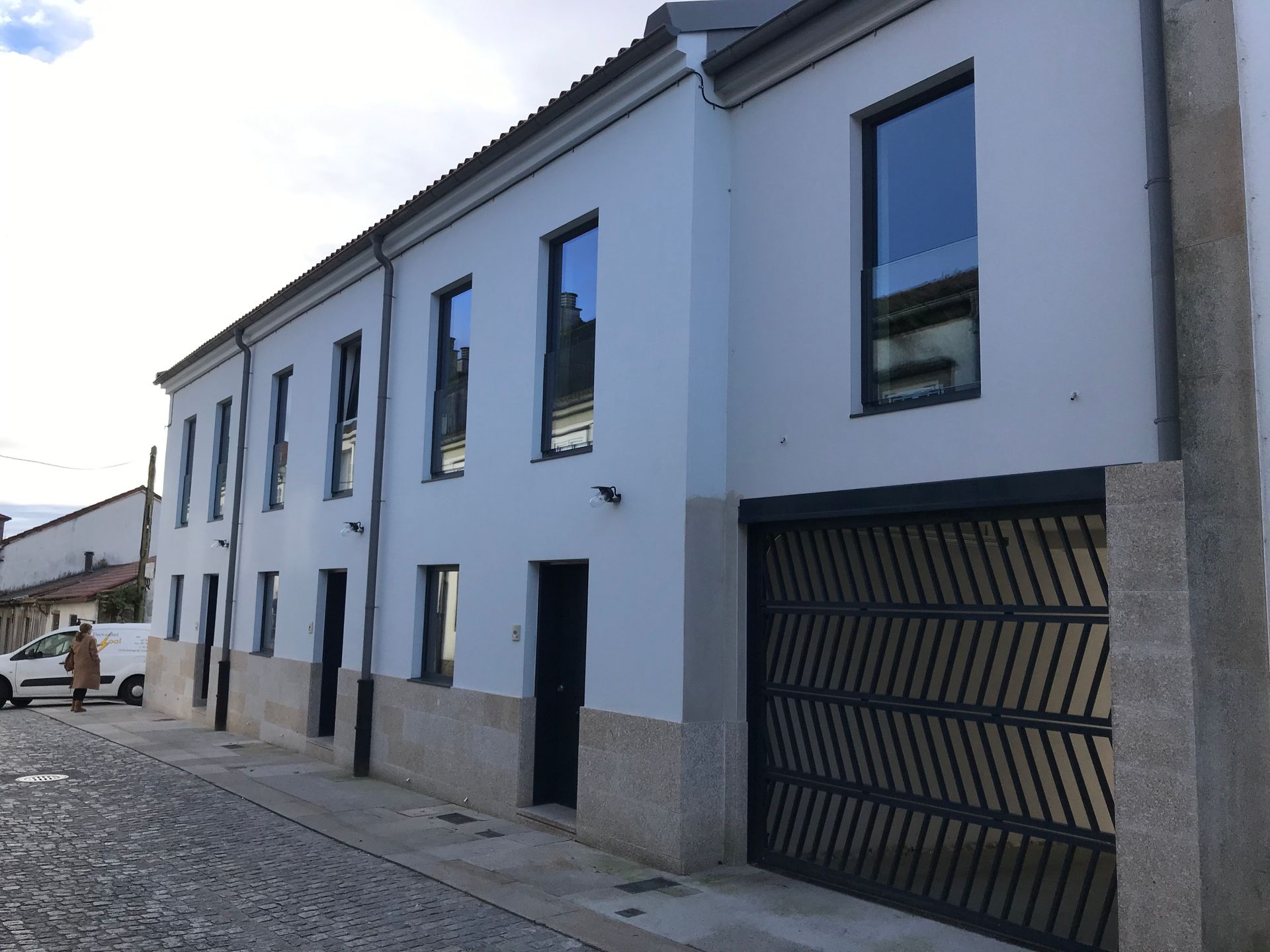 Un edificio blanco con una puerta de garaje negra
