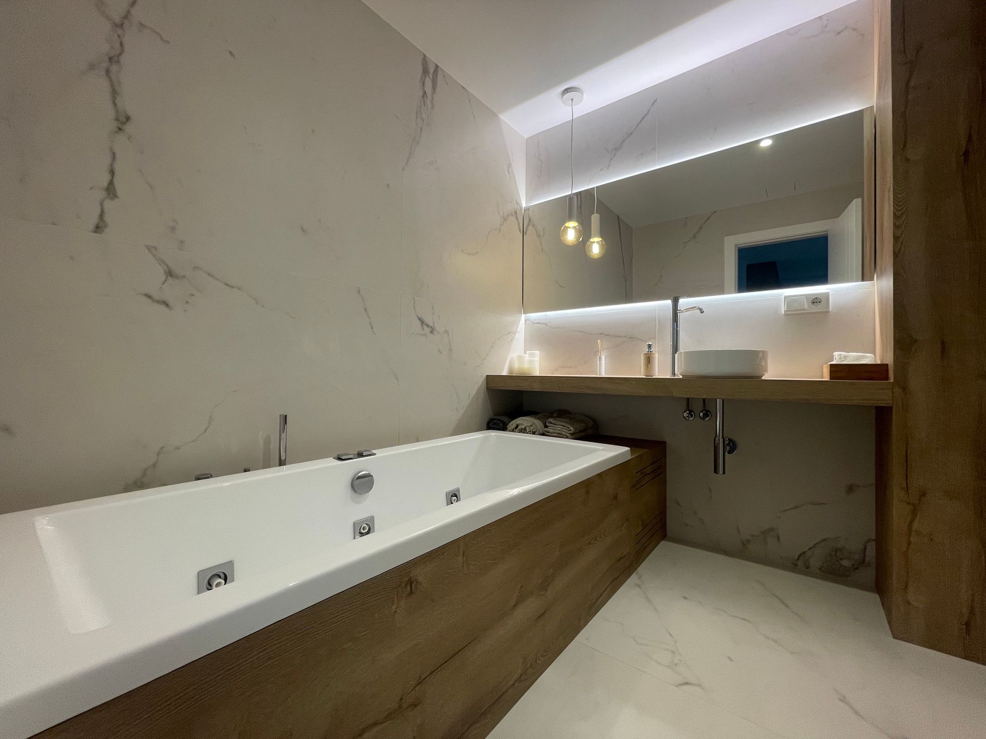 Un baño con bañera, lavabo y espejo.